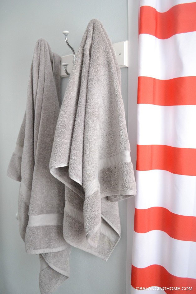 cleaning-organizing-bathroom-with-pedestal-sink-towel-hooks-red-white-striped-shower-curtain